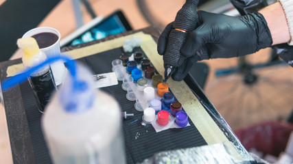 Close-up of tattoo artist work place parts and paint, machines and other equipment. Professional...