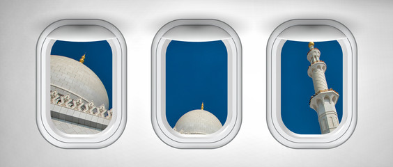 Airplane interior with window view of Abu Dhabi Sheikh Zayed Mosque, UAE. Concept of travel and air transportation