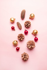 Fototapeta na wymiar Autumn composition. Christmas pine cones, red gold balls on pink background.