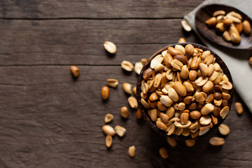 Roasted peanuts, salt, put in a cup. Brown was placed on the wooden floor.