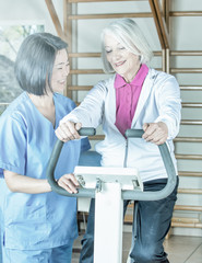 Senior retired elderly people in sports clothing in gym, working out with the help of trainer