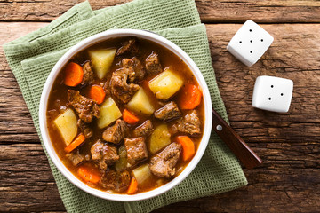 Fresh homemade beef stew with carrot and potatoes served in bowl, photographed overhead