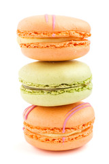 Orange and green macarons or macaroons cakes isolated on white background,  side view.