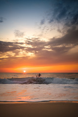 Naklejka na ściany i meble surfers at sunset