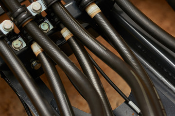 Close up view of hydraulic pipes of heavy industry machine. Low key.