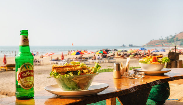 Lunch with green salad and beer on Arambol beach with sea view, Goa, India