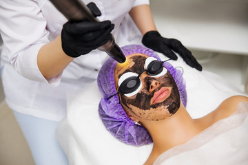 Process of carbon face laser peeling procedure in beauty salon. Laser pulses clean skin of the...