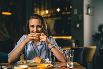 beautiful woman drinking coffee in fancy restaurant