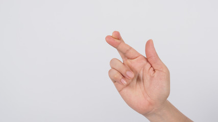 Male's right hand doing Crossed fingers sign on white background.