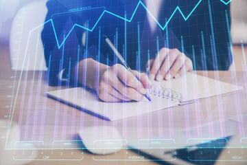 Forex graph on hand taking notes background. Concept of research. Multi exposure