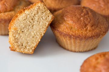 Cupcake cut in half in front of several muffins on a white background