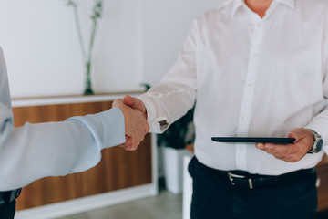 closeup businesspeople handshaking in office