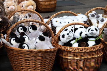 many soft toys in wicker baskets of panda, owl, monkey, camels, penguins. gifts for children