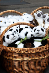 many soft toys wicker baskets of panda, owl, monkey.  pandas close up
