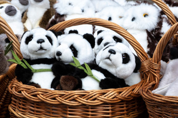 many panda soft toys in a wicker basket. close up