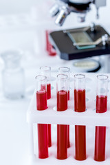 blood in glass tubes on background of microscope