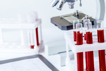 blood in glass tubes on background of microscope