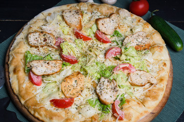Chicken pizza on a wooden tray.