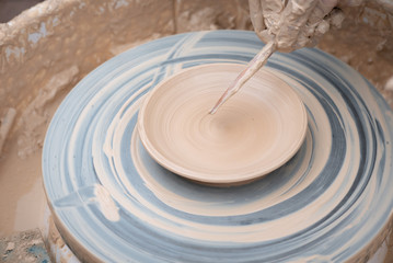 Fototapeta na wymiar Clay plate rotating on the pottery wheel