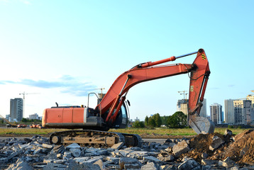 Large tracked excavator works in a gravel pit. Loading of stone and rubble for its processing at a concrete factory into cement for construction work. Cement production factory on mining quarry