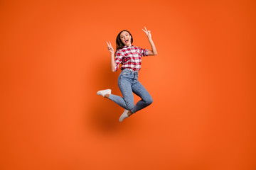 Obraz na płótnie Canvas Full body length size photo of rejoicing delightful pretty attractive active making motions giving double v-sign jumping up in denim modern plaid red clothes isolated bright color background