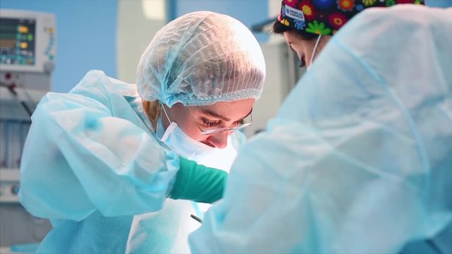 A team of surgeons has a major plan during surgery, a blue light operating room, a rhinoplasty operation to improve the aesthetics of the nose. Medetsina, plastic surgery.