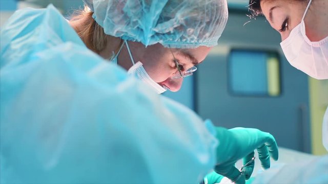 A team of surgeons has a major plan during surgery, a blue light operating room, a rhinoplasty operation to improve the aesthetics of the nose. Medetsina, plastic surgery.