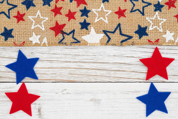Red, white and blue stars on burlap on a weathered whitewash wood background