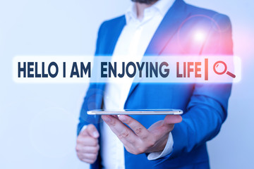 Text sign showing Hello I Am Enjoying Life. Business photo showcasing Happy relaxed lifestyle Enjoy simple things Man in the blue suite and white shirt holds mobile phone in the hand