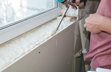 Contractor install and insulate house window sill with caulcing gun