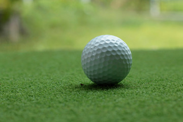 Golf ball on green grass in the evening golf course