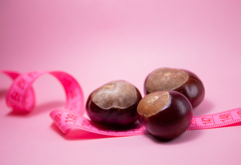 A centimeter tape and chestnuts near it. Fitness concept.