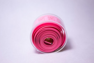 Pink tape measure isolated on a white background.