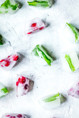 frozen red berries in ice cubes on stone background top view