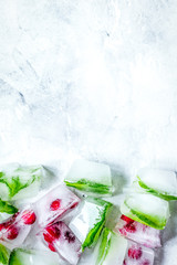 ice cubes with red berries and mint top view gray stone background mockup