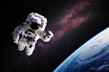 Astronaut in outer space over of the Earth with sun light. City lights on planet. Elements of this...