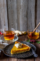 Pumpkin pie on a wooden background. Traditional recipe.