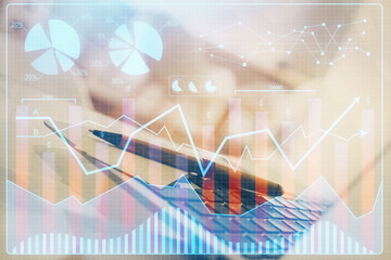 Financial chart drawing and table with computer on background. Double exposure. Concept of international markets.