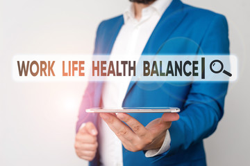 Text sign showing Work Life Health Balance. Business photo showcasing Stability and Harmony to prevent burnt out Man in the blue suite and white shirt holds mobile phone in the hand