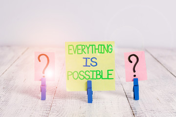 Conceptual hand writing showing Everything Is Possible. Concept meaning Any outcome could occur Anything can happen Crumbling sheet with paper clips placed on the wooden table