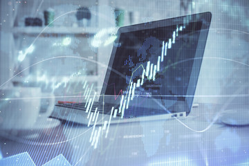 Stock market graph and table with computer background. Double exposure. Concept of financial analysis.