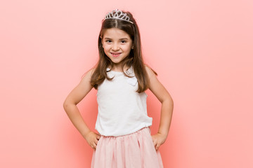 Little girl wearing a princess look confident keeping hands on hips. © Asier