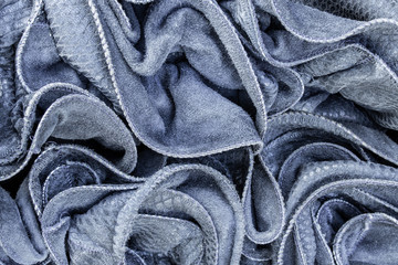 Background in the form of material made of gray leather with a blue tint with numerous wavy folds...