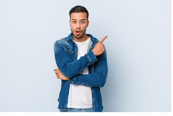 Young handsome filipino man pointing to the side