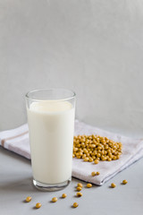 Soy milk in a glass glass. Vegetarian food. Organic products, healthy food concept. Vertical orientation, side view, copy space.