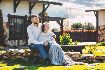 Beautiful and happy young couple man and woman in a beautiful garden in the yard of a country house