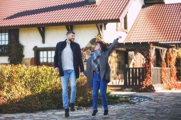 Beautiful and happy young couple man and woman in a beautiful garden in the yard of a country house