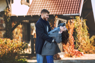 Beautiful and happy young couple man and woman in a beautiful garden in the yard of a country house
