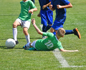 Kids are playing soccer in summer