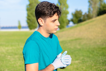 Serious pensive eco activist working in park. Young man wearing uniform shirt and protective...
